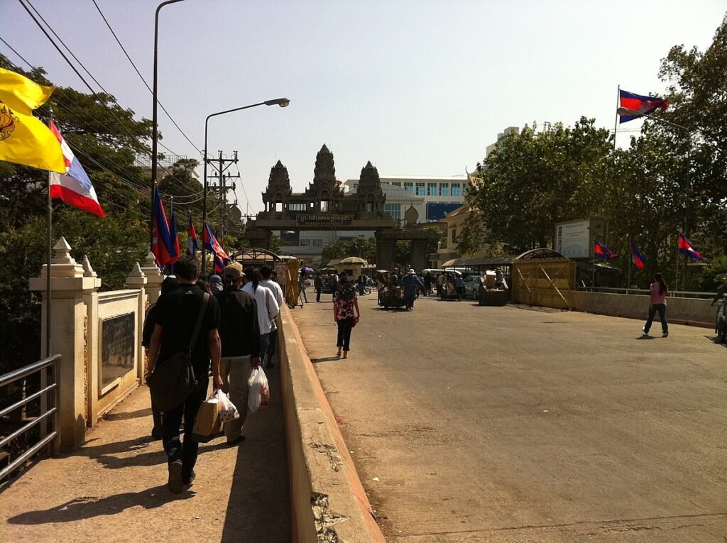Travelers walking near the Thailand–Cambodia border crossing under heightened security